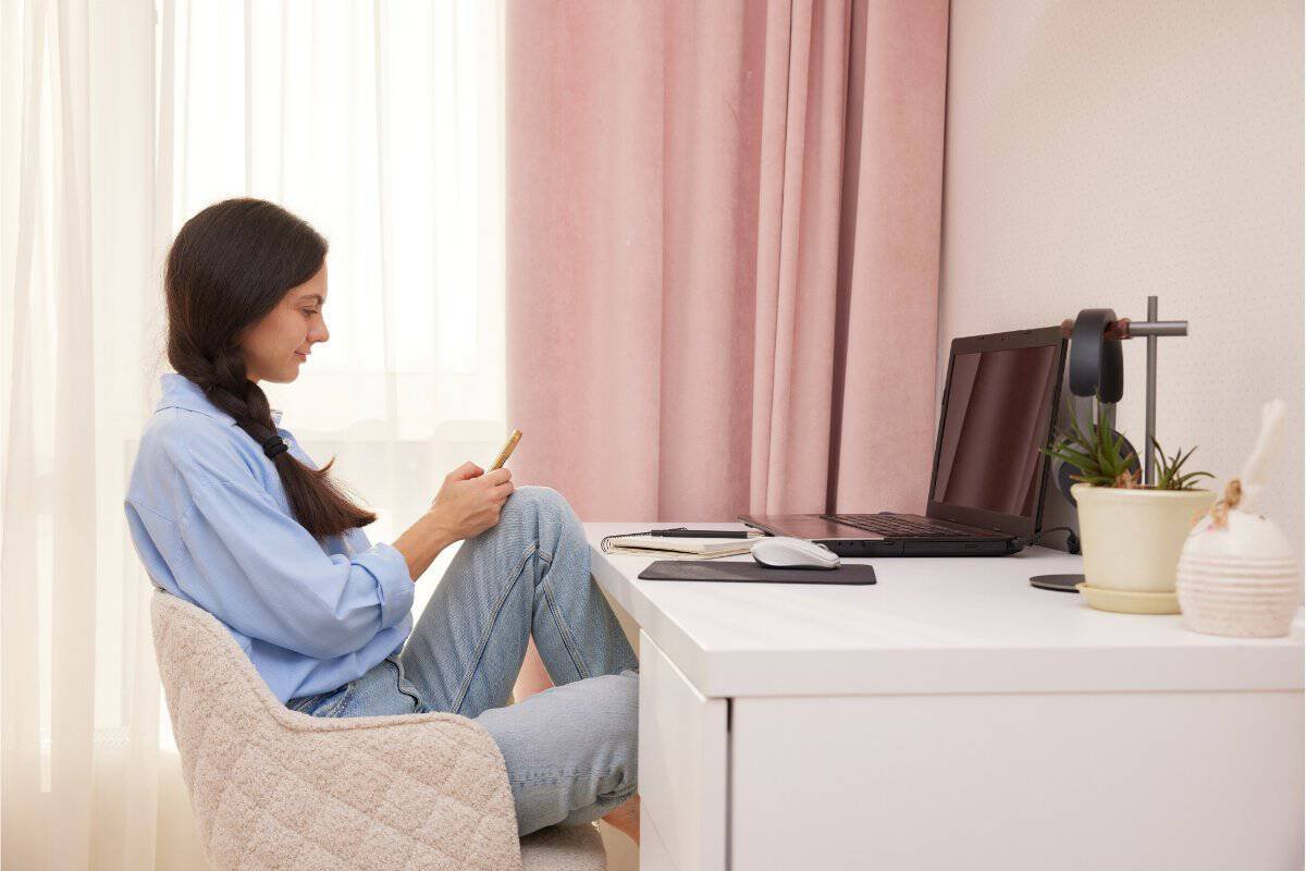 Donna seduta alla scrivania mentre organizza il lavoro da casa