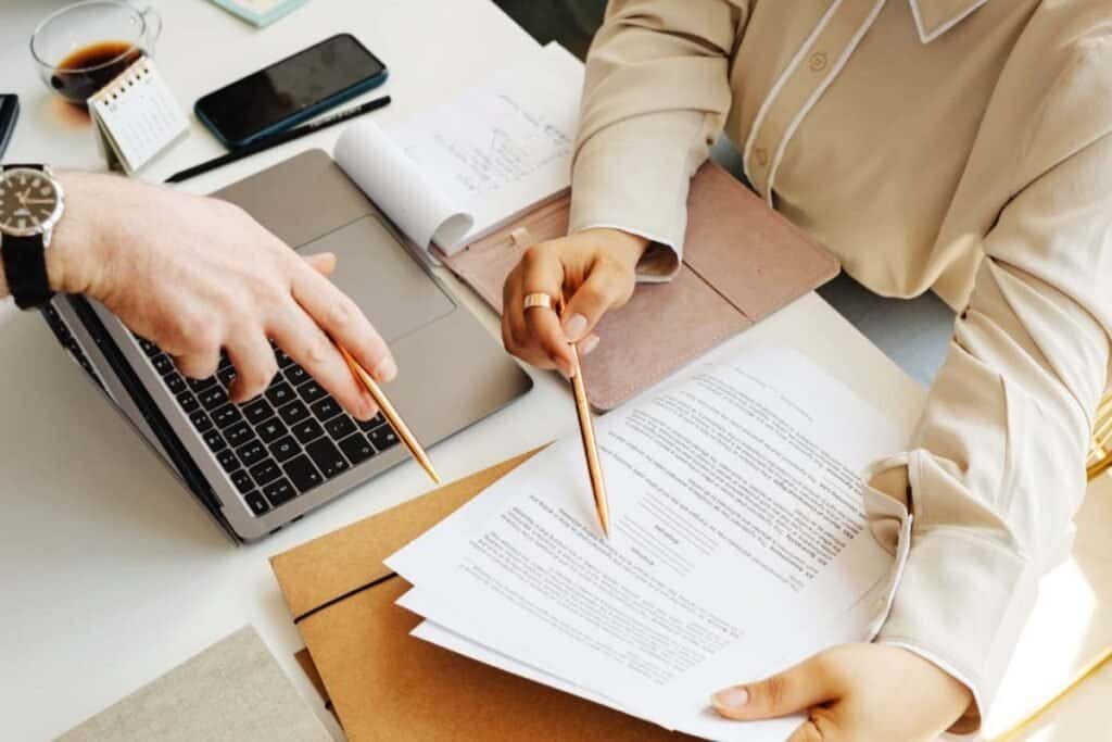 persone che lavorano su documenti e laptop con organizzazione e focus sulla costanza