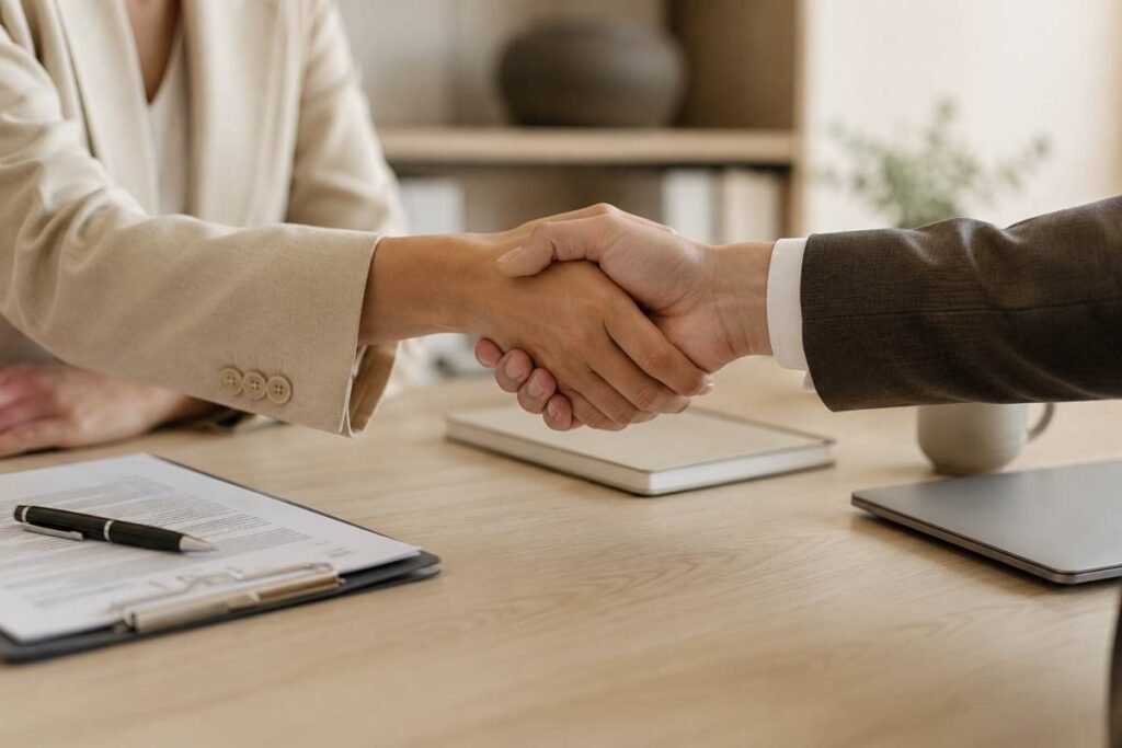 Due persone si stringono la mano durante un colloquio di lavoro, immagine che rappresenta i Bonus INPS 2026 e le nuove assunzioni a tempo indeterminato.