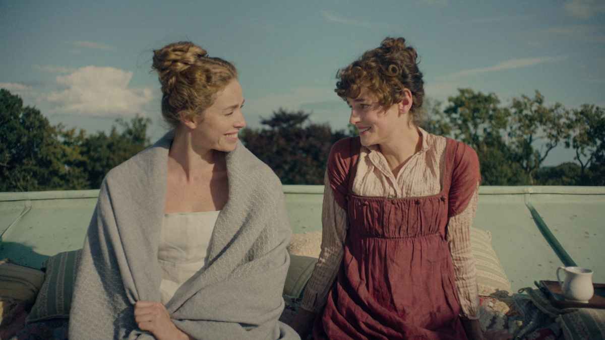 Emma Corrin e Freya Mavor interpretano Elizabeth e Jane Bennet sedute all'aperto nella serie Netflix Orgoglio e Pregiudizio