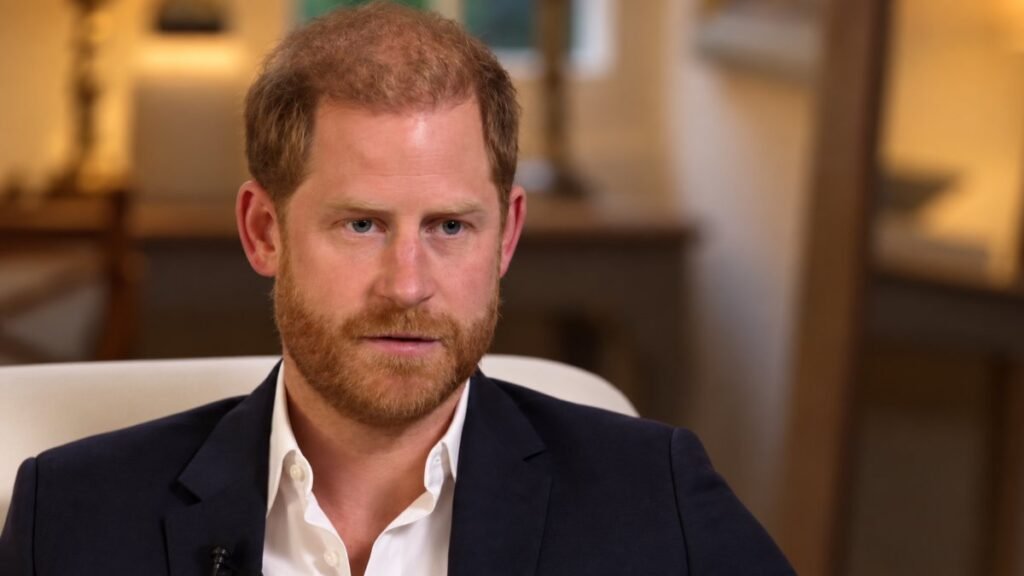 Il principe Harry durante un'intervista con espressione seria e riflessiva in giacca scura e camicia bianca